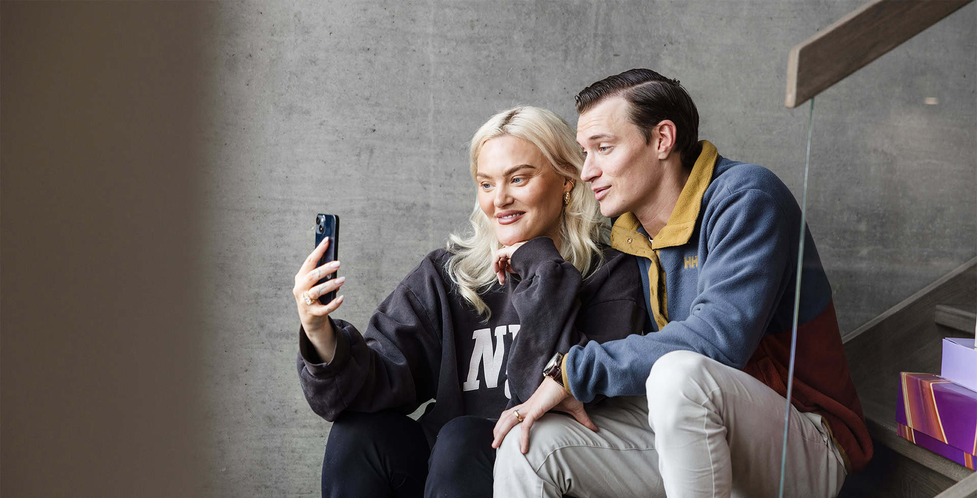 Lisa och Henrik Borg sitter i en trappa och tar en selfie tillsammans.