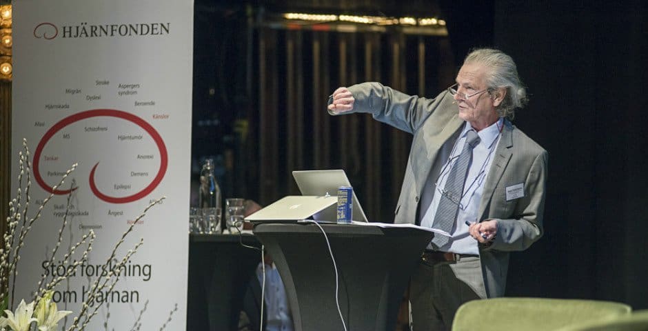 Mats Fredrikson talar i en mikrofon och illustrerar med sin hand.