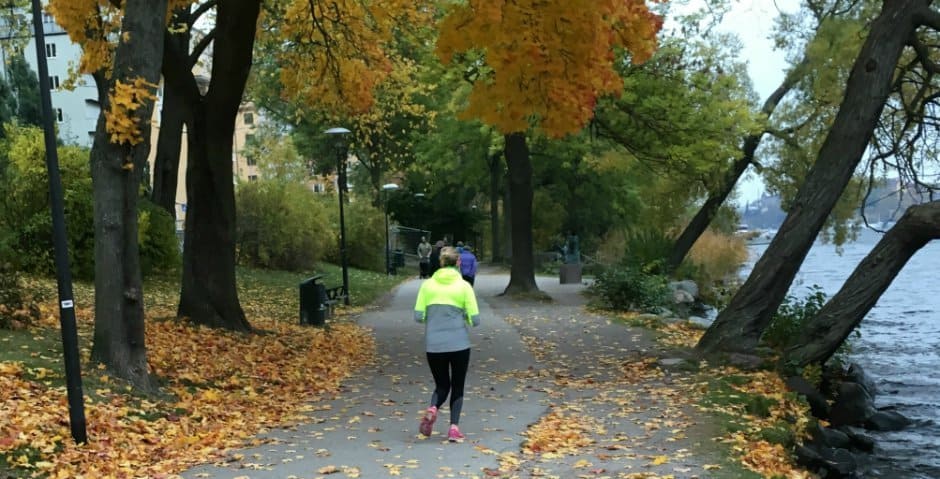 En kvinna joggar längs vattnet.