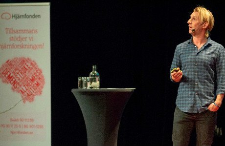 Anders Hansen står på en scen och talar.