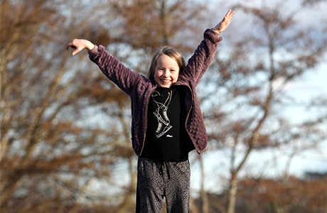 Porträtt av Vilma som står med armarna i luften.