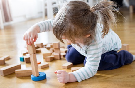 Flicka i fyraårsåldern leker med klossar.
