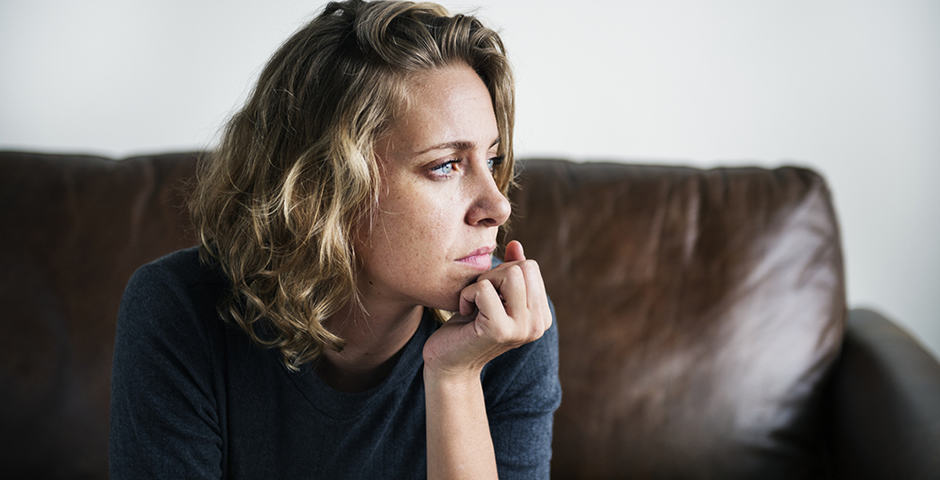 Kvinna som lutar hakan mot handen och ser fundersam ut.