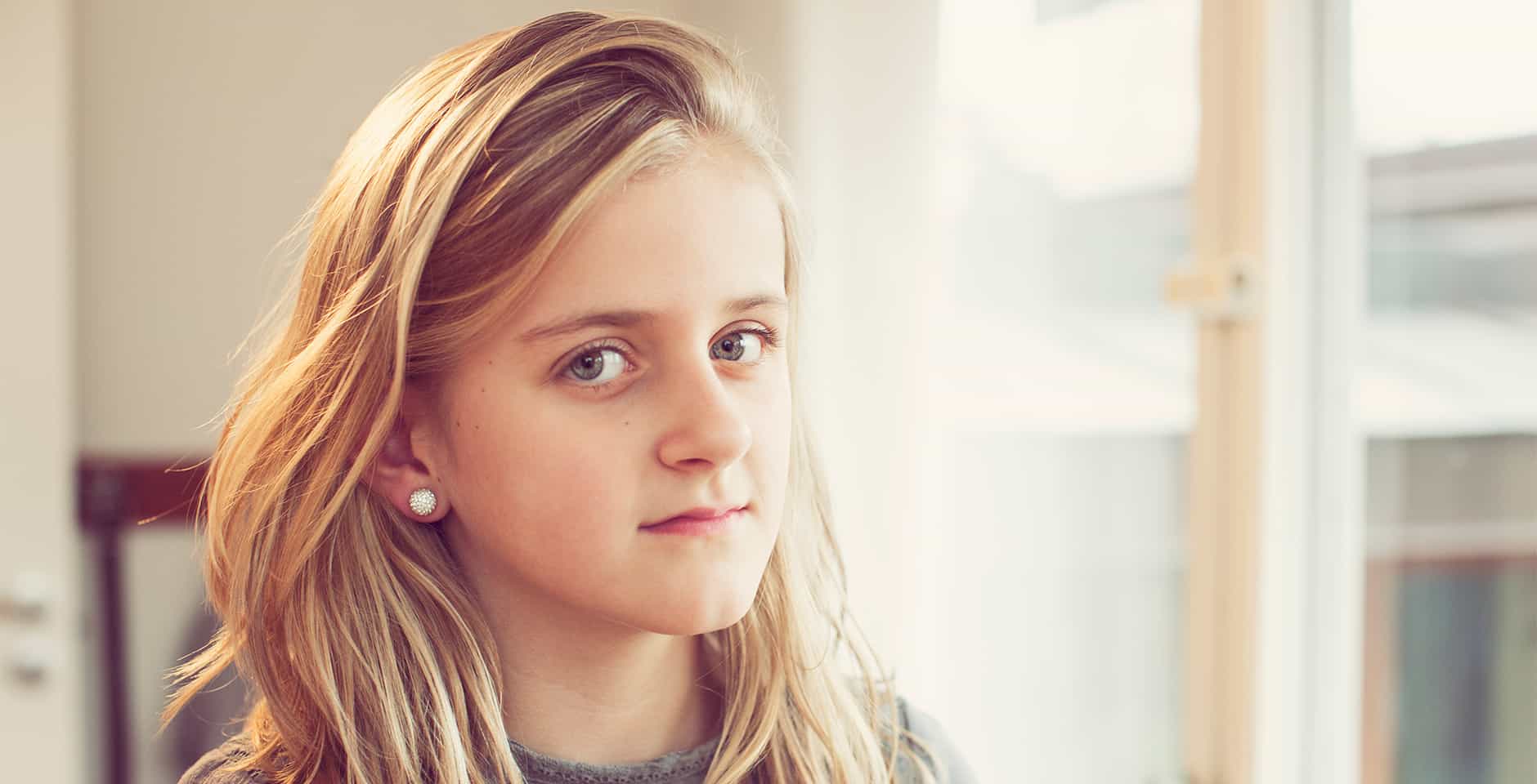 Ung flicka tittar mot kameran.
