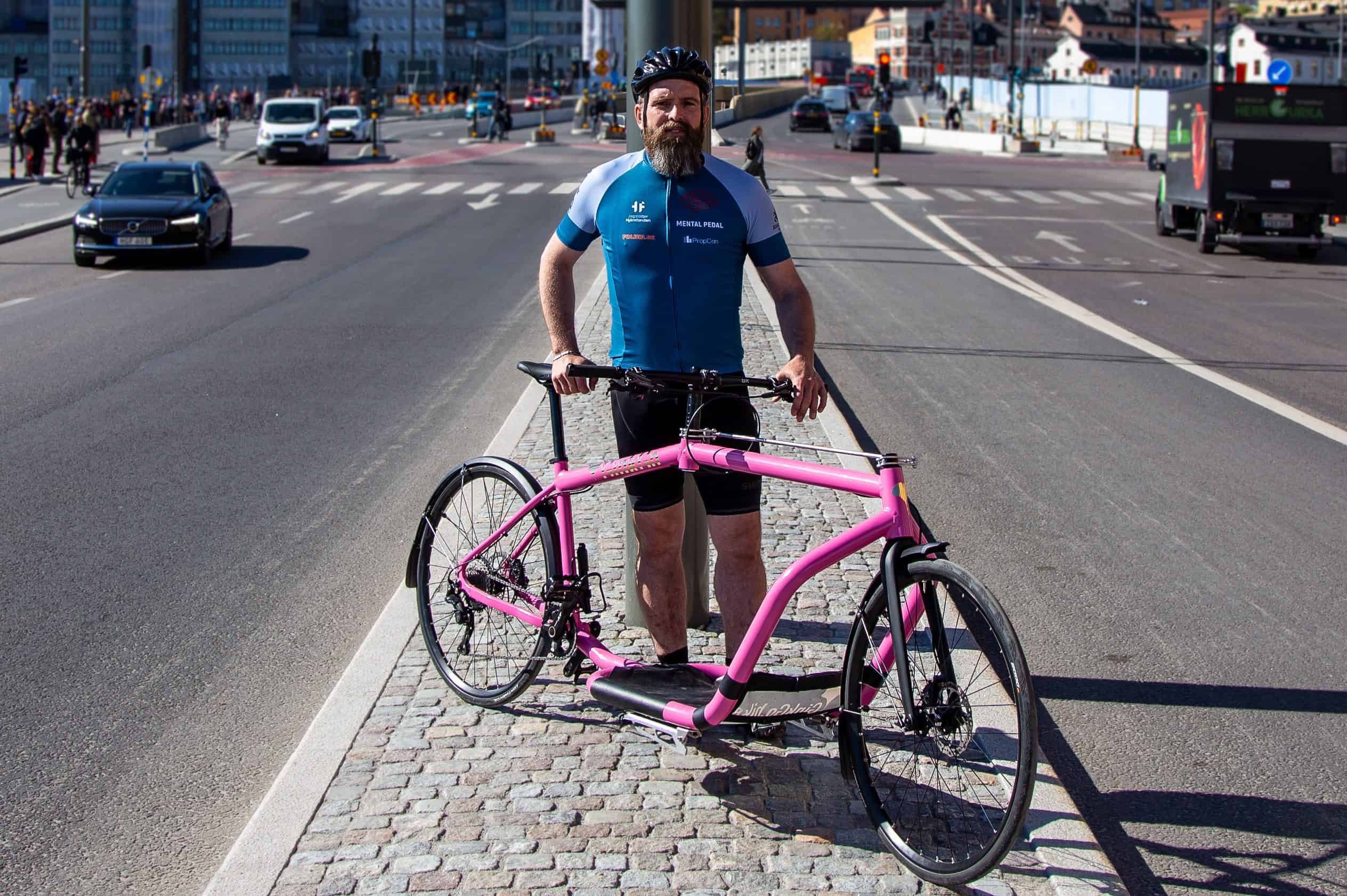 Fredrik står med sin cykel på refug i slussen mellan två körbanor.