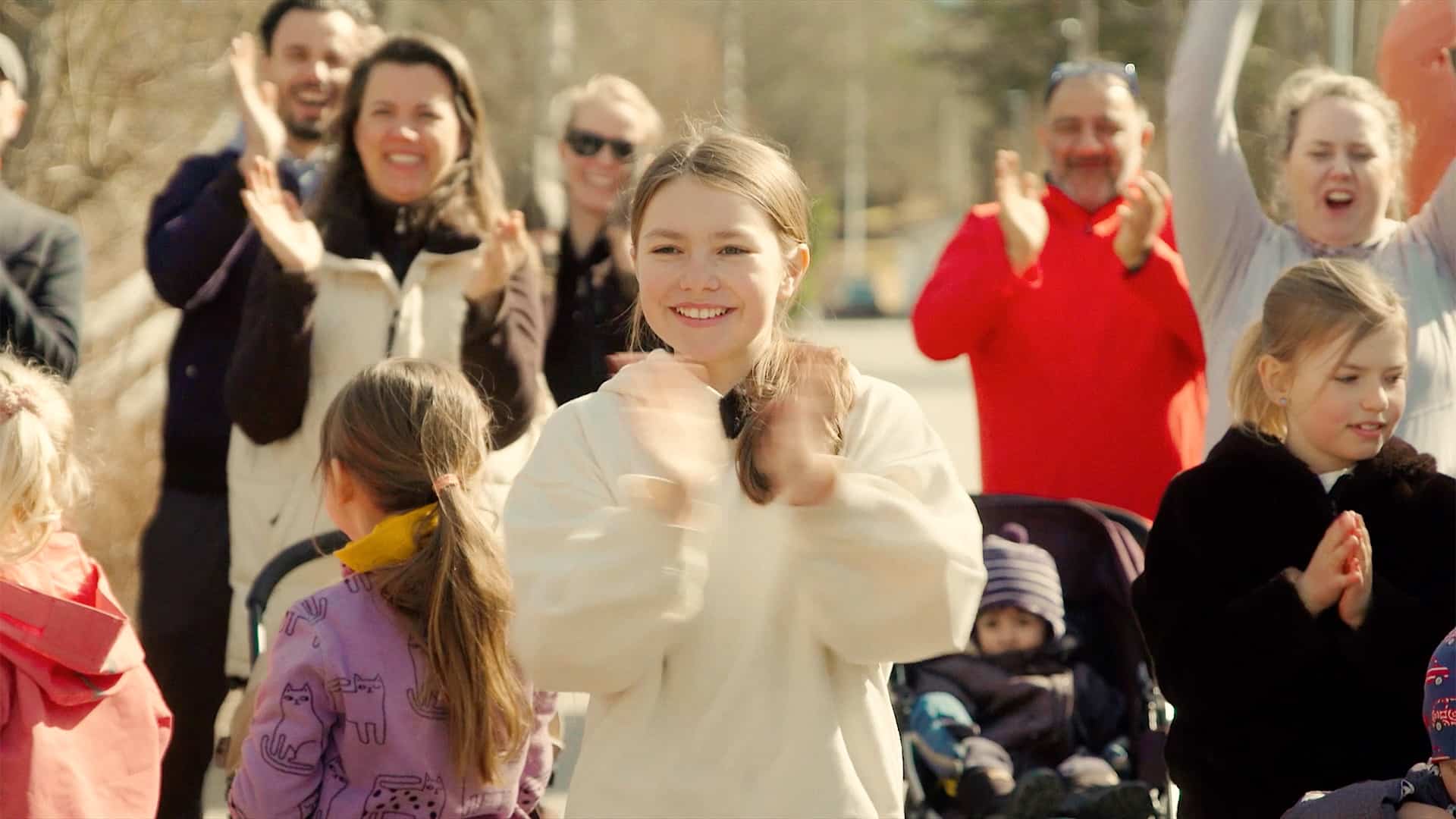 Bild på barn som tackar deltagare i skolloppet för deras engagemang genom att klappa händerna.