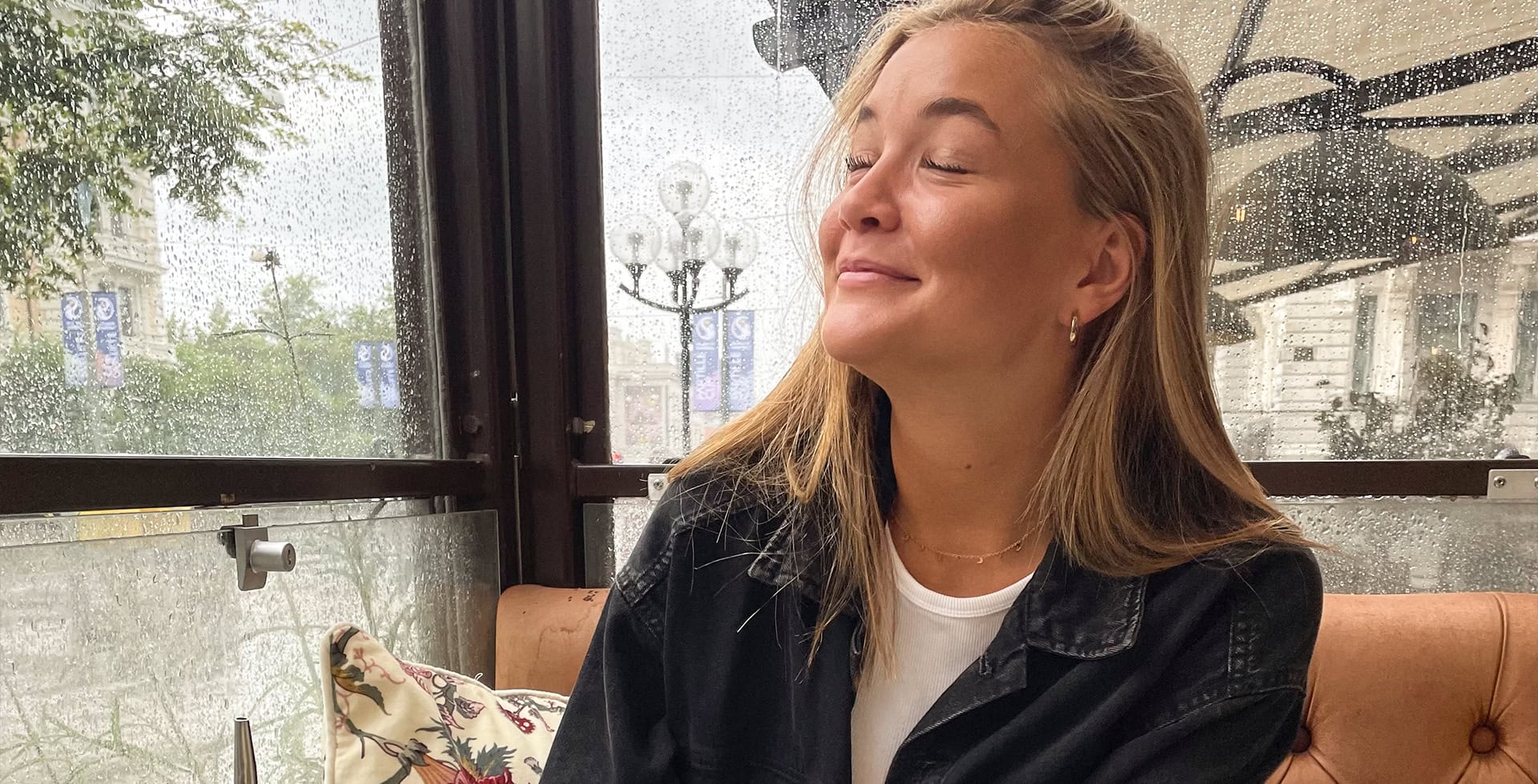 Tuva Malmström sitter i ett regnigt glashus.