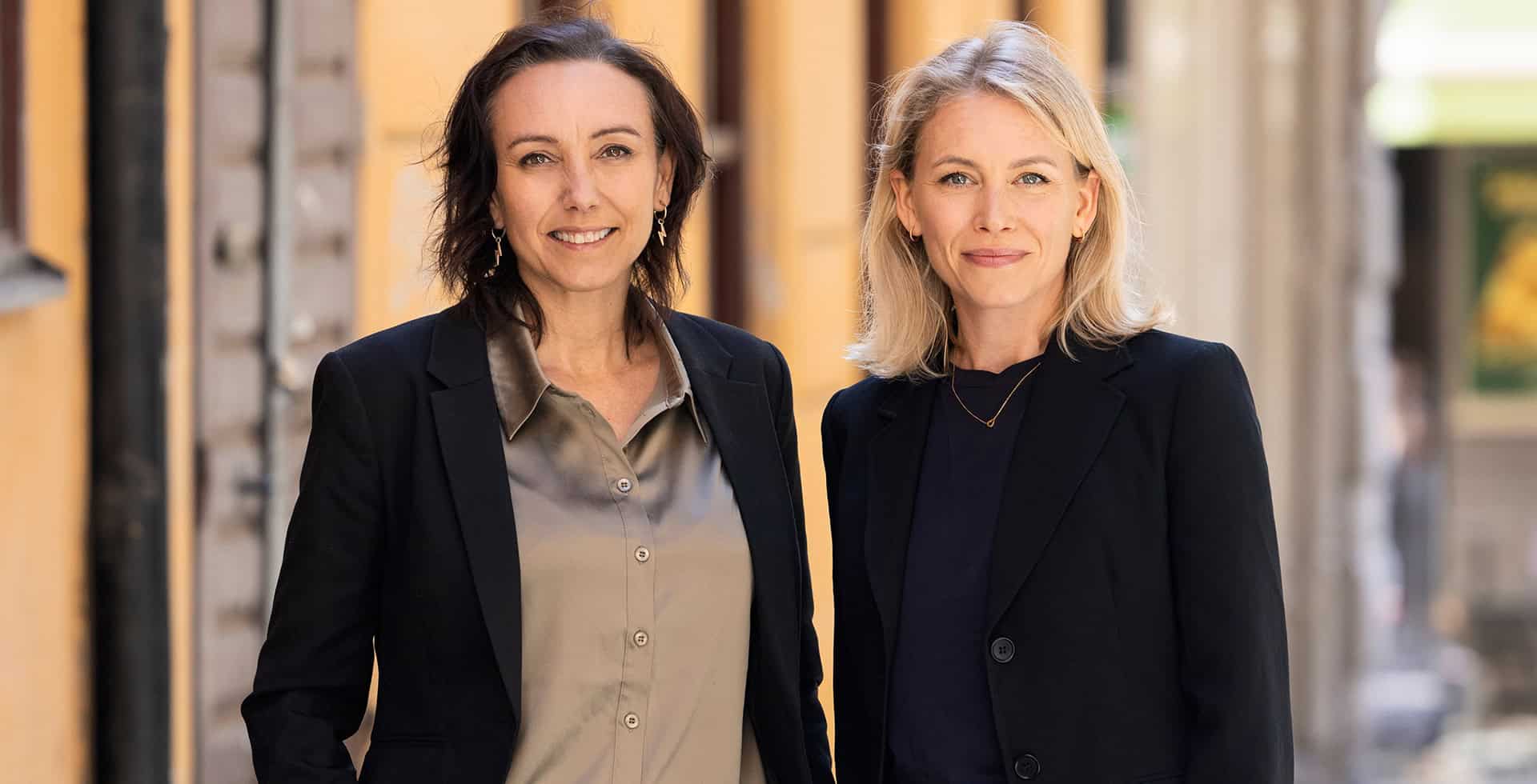 Porträtt av Emma Cajander och Lena Hazelius som står utomhus.