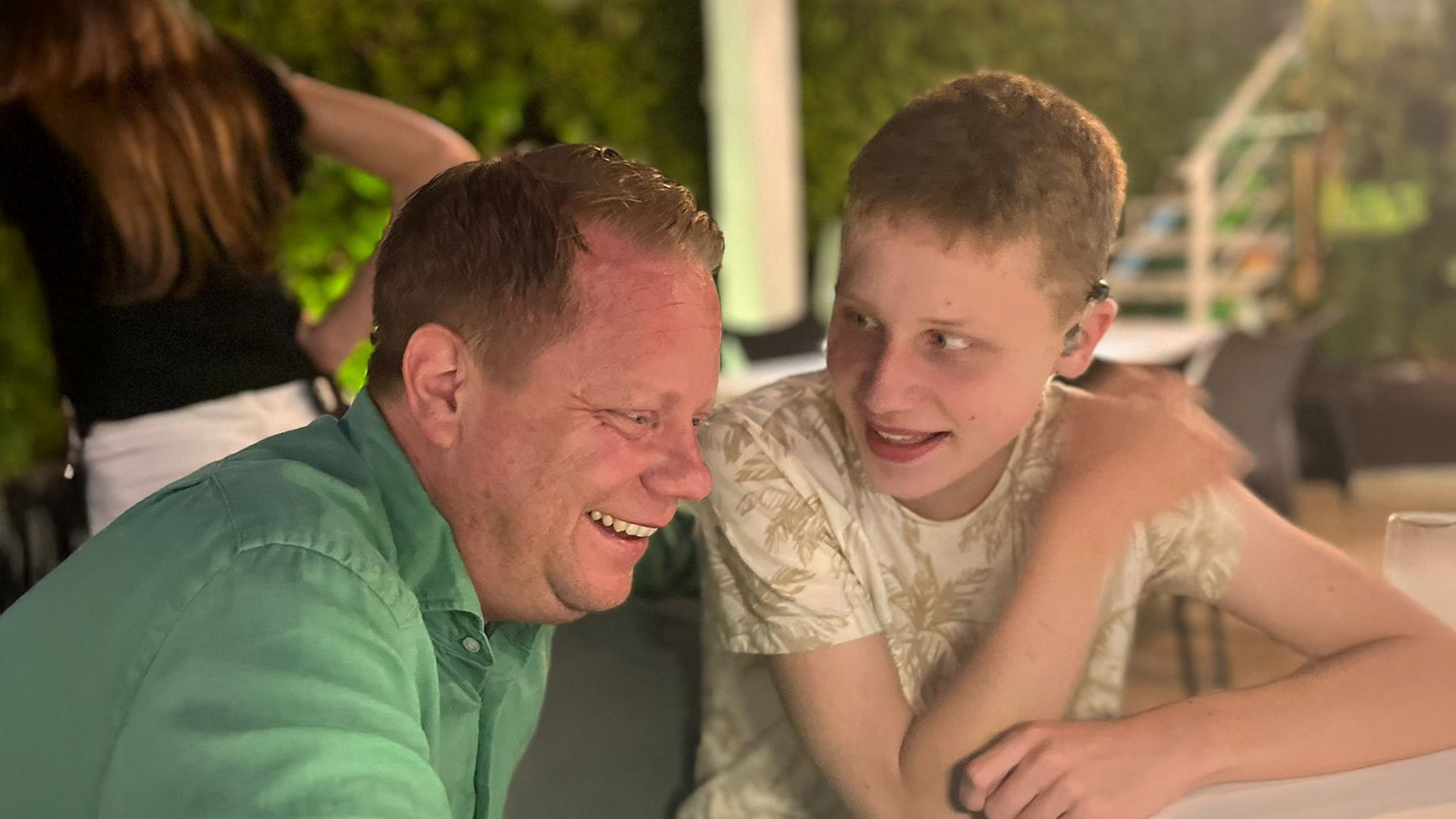 Christian sitter tillsammans med sin son Philip vid ett bord och skrattar.